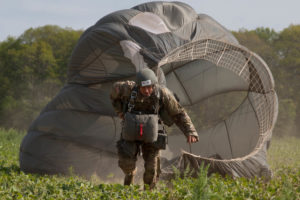 U.S. Army Paratrooper Warrent Officer Greg Suchanek, Special Operations Detachment (NATO) drags his parachute toward a target during Leapfest 2016 in West Kingston, R.I., August 4, 2016. Leapfest is an International parachute training event and competition hosted by the 56th Troop Command, Rhode Island Army National Guard to promote high level technical training and esprit de corps within the International Airborne community. (U.S. Army photo by Sgt. Brady Pritchett / Released)